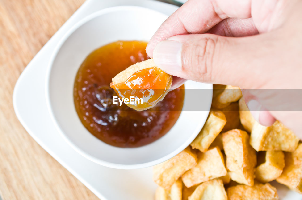 Cropped hand holding food with dip
