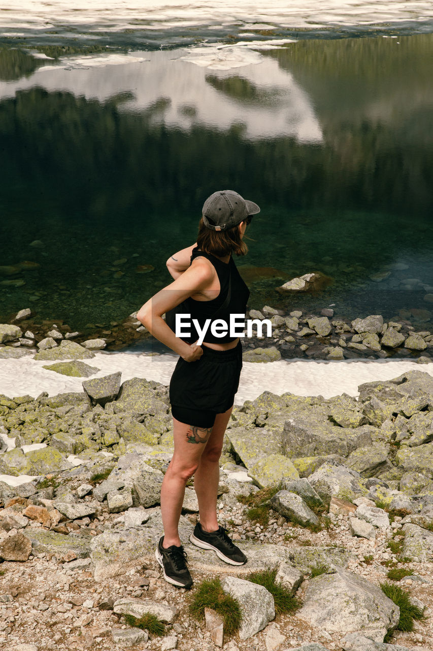 Man standing on rock looking at lake