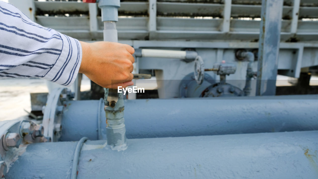 Cropped hand of man holding valve