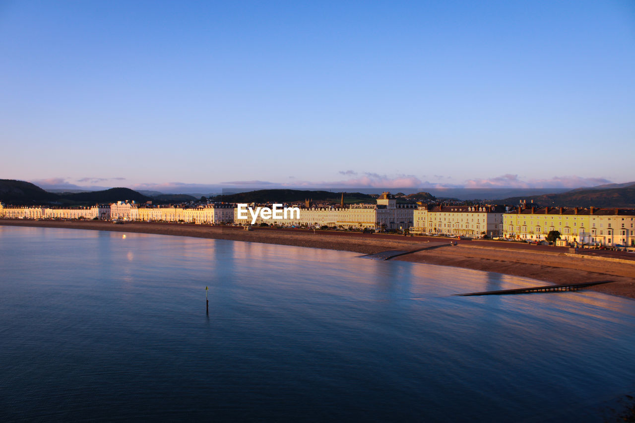 Sea by buildings against clear blue sky llandudno esplanade 