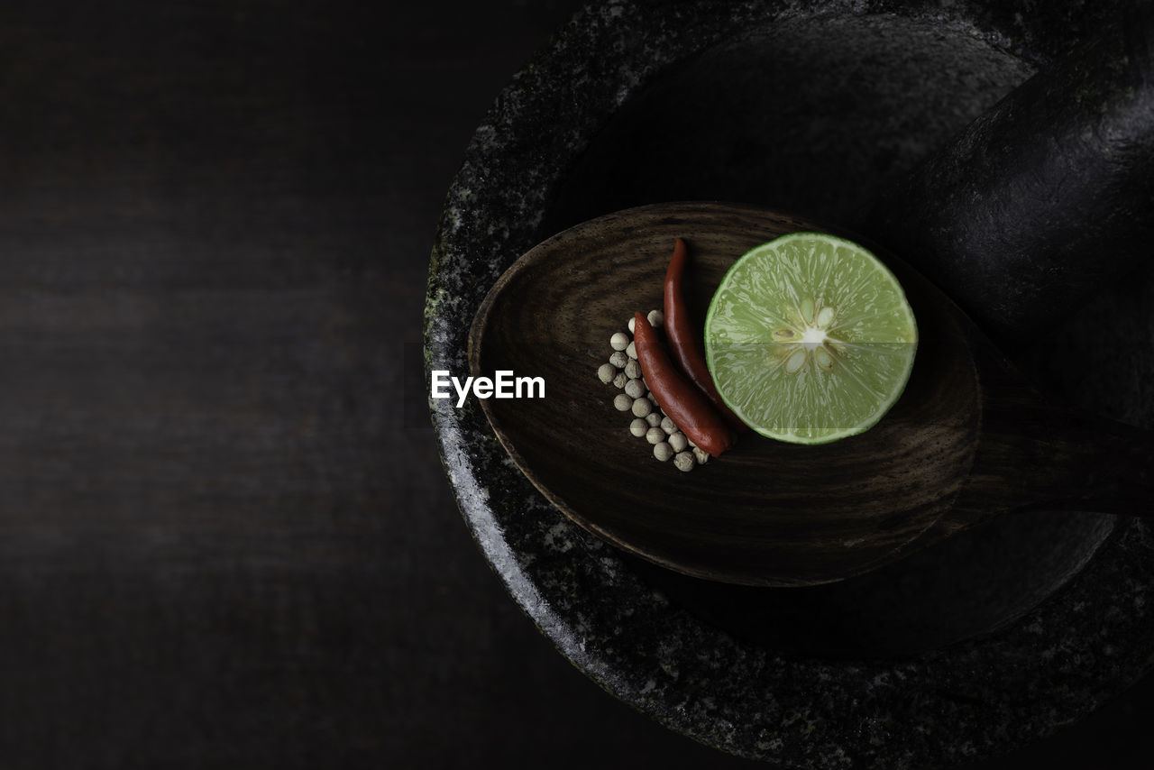Directly above shot of ingredients in spoon over mortar and pestle on table