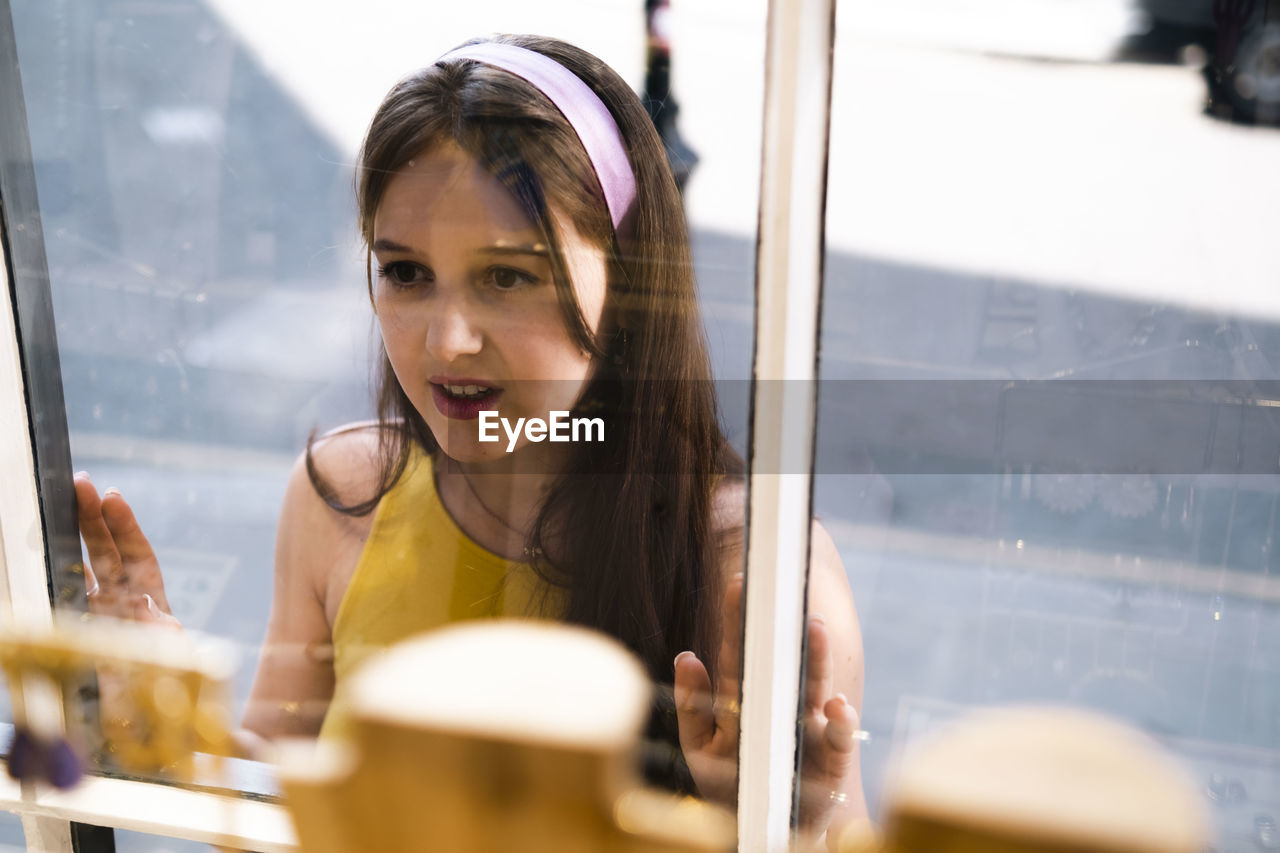 Woman with long hair looking in store window