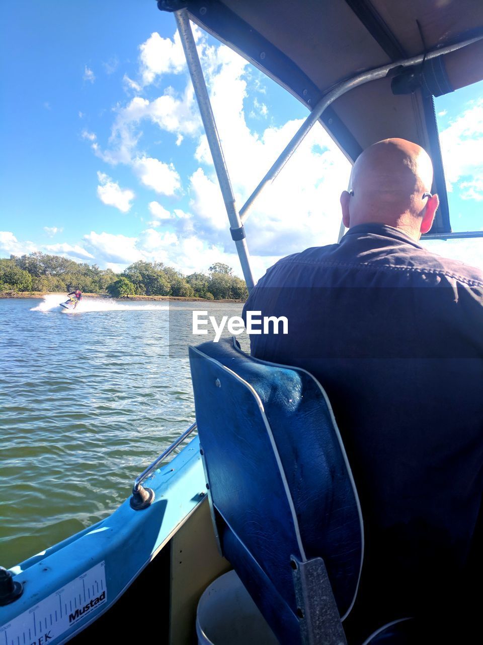 REAR VIEW OF MAN SITTING IN SEA