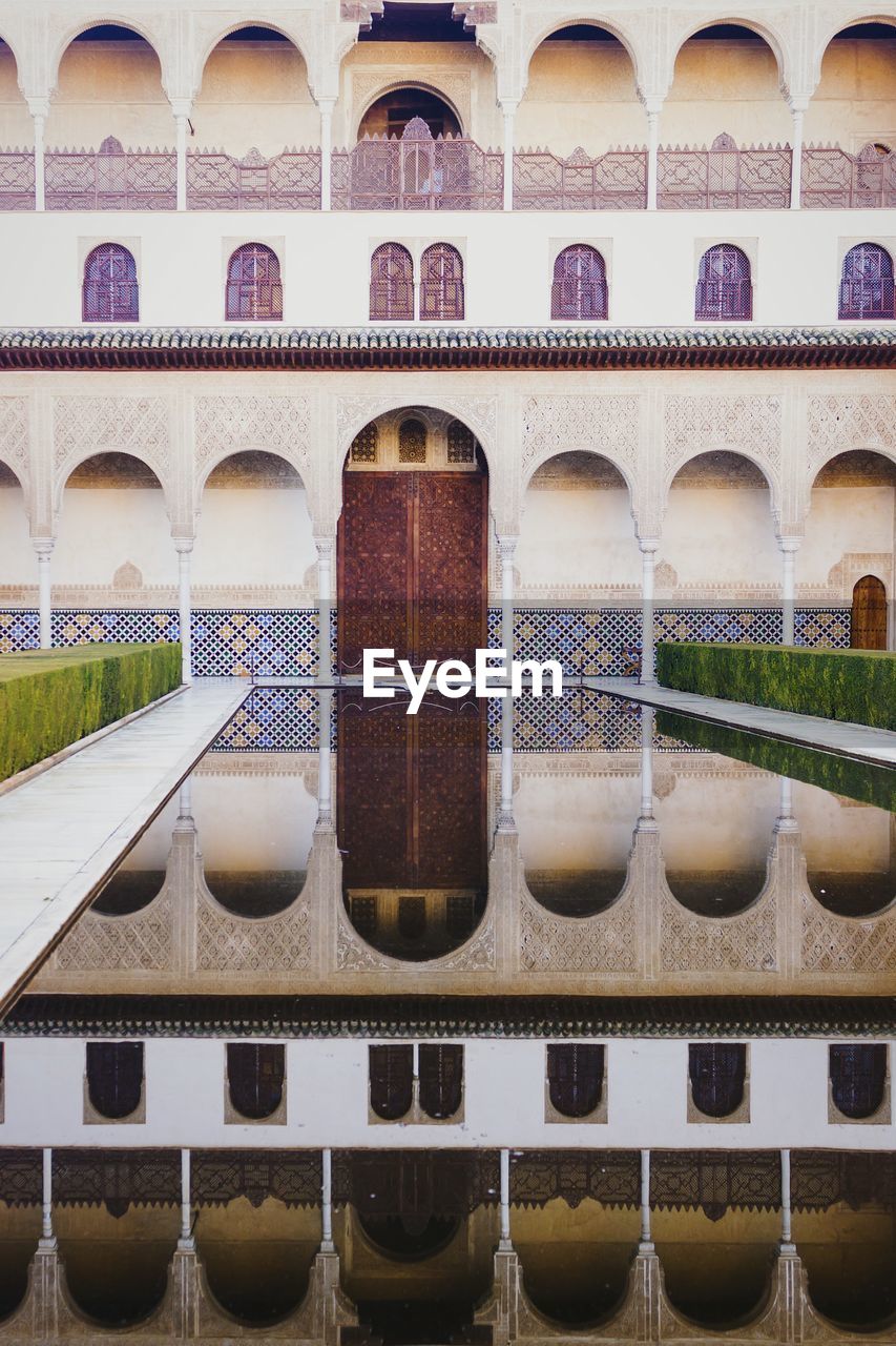 VIEW OF BUILDING WITH REFLECTION OF WATER IN FOREGROUND