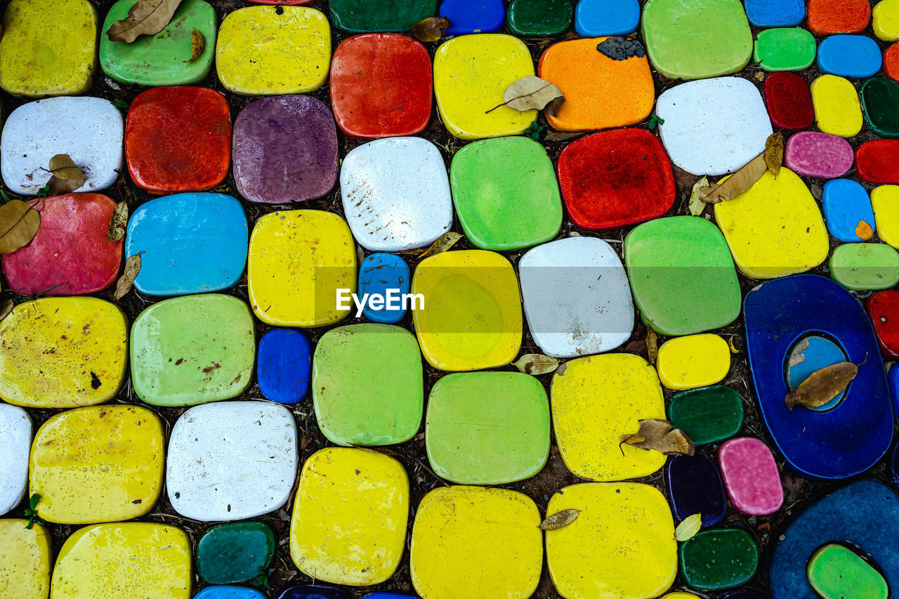 Top view on pieces of multicolored ceramic tiles decorated in garden. old pavement of tiles textured