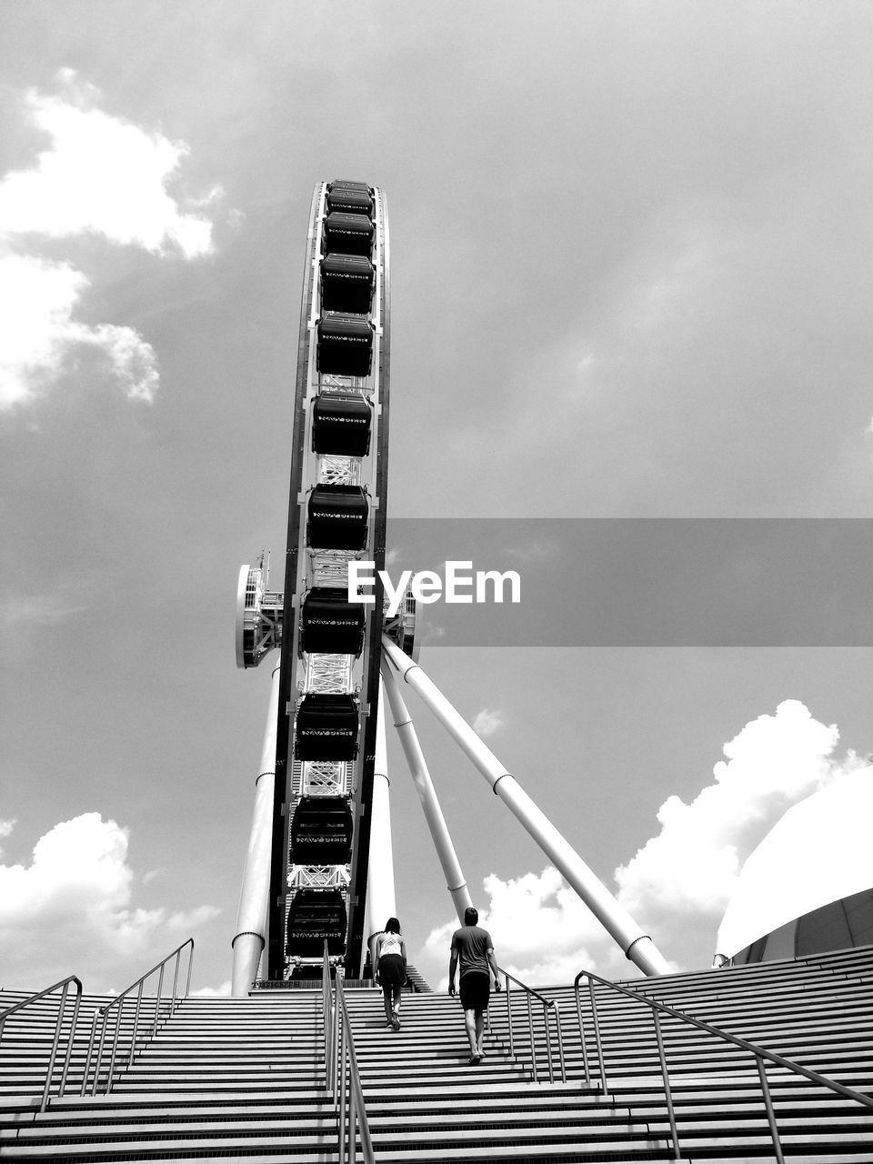 Low angle view of ferris wheel by building against sky