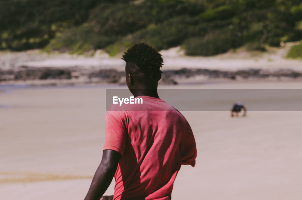 Rear view of man standing on beach