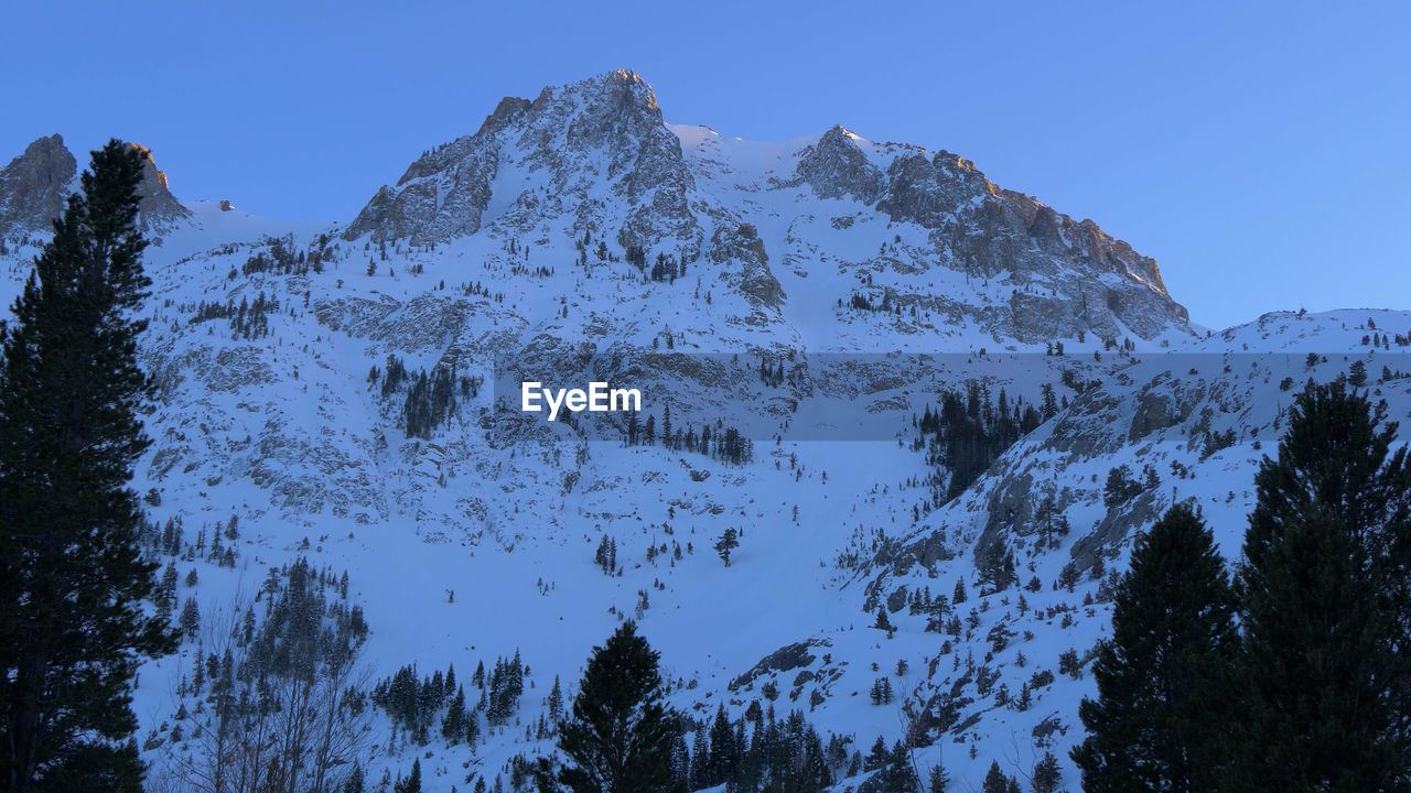 LOW ANGLE VIEW OF SNOWCAPPED MOUNTAIN AGAINST CLEAR SKY