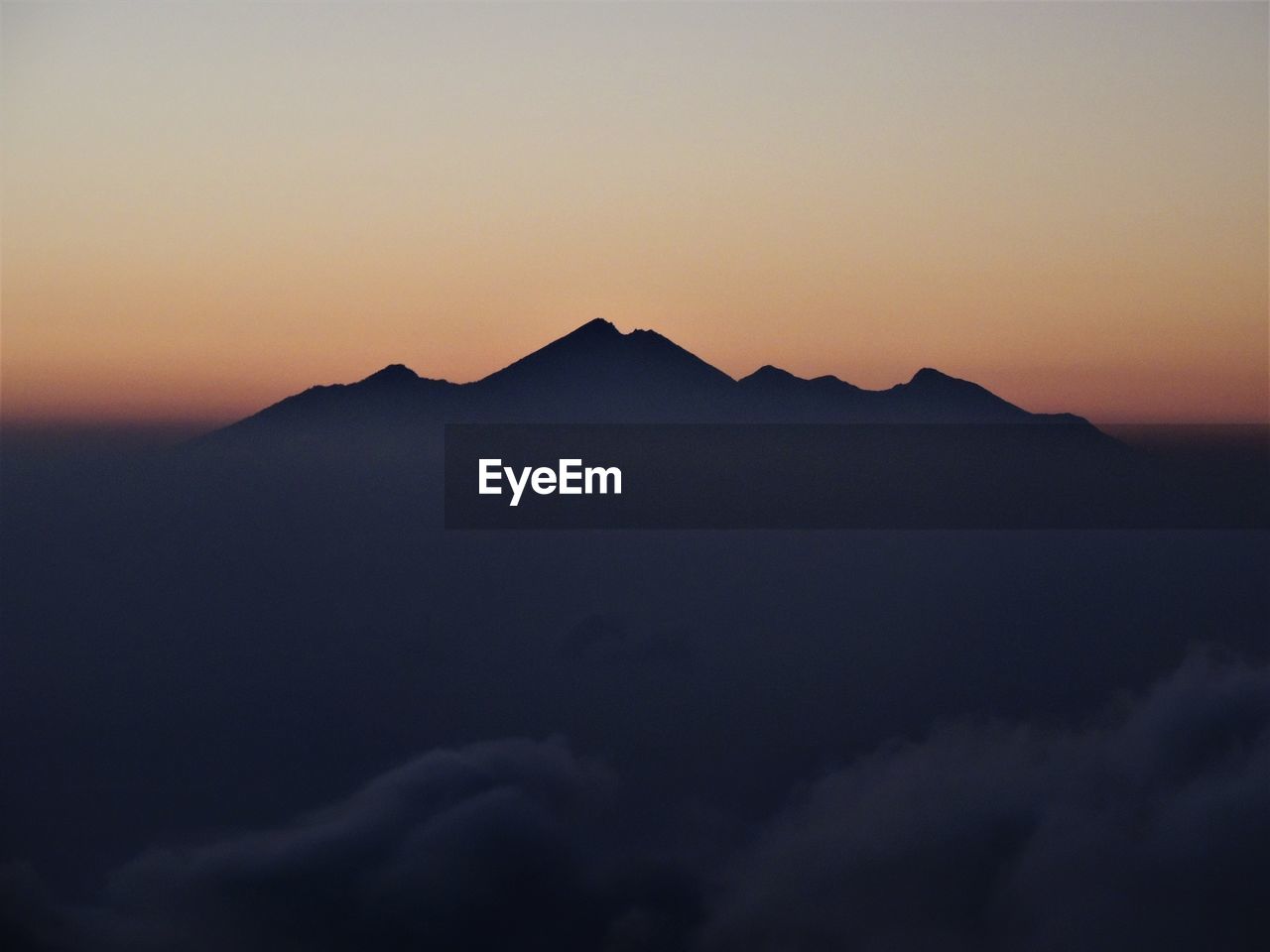 Scenic view of silhouette mountains against clear sky during sunset