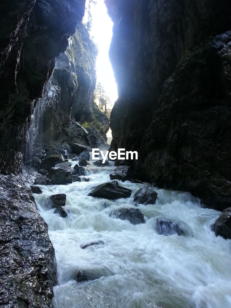 SCENIC VIEW OF WATERFALL AGAINST SKY