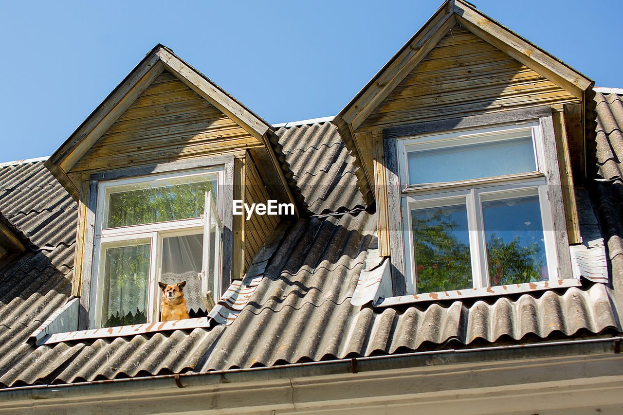 LOW-ANGLE VIEW OF HOUSE AGAINST CLEAR SKY