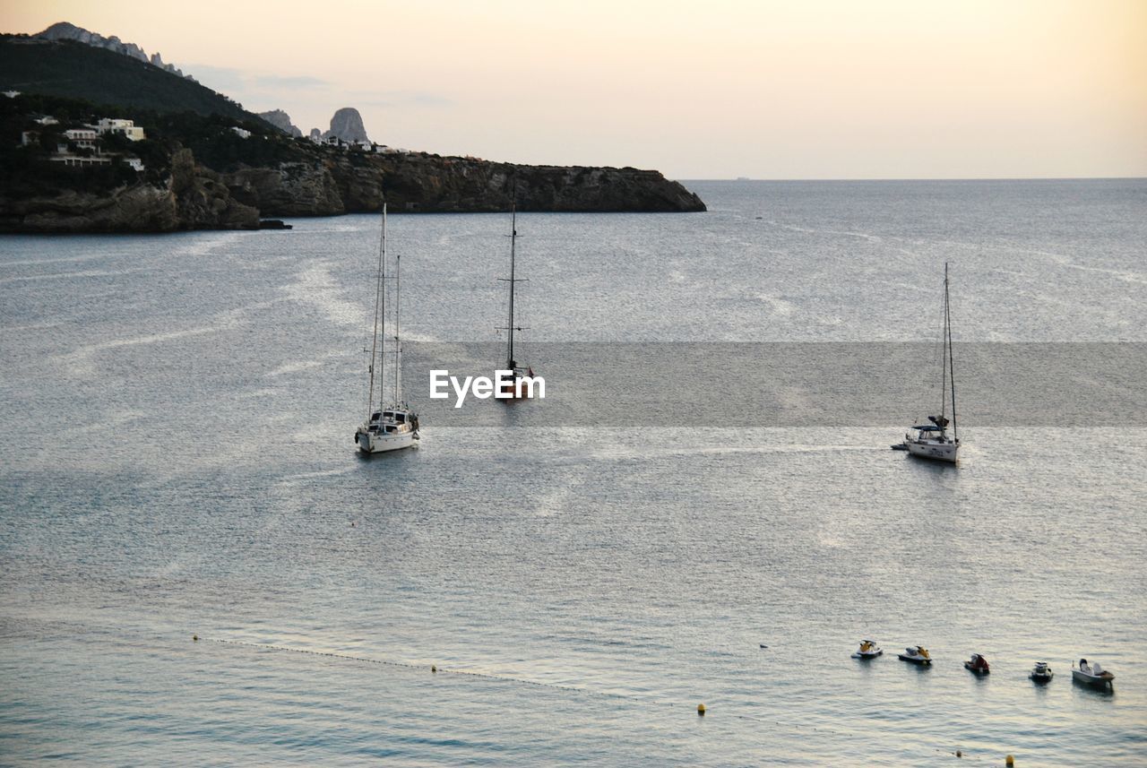 Sailboats in sea against sky