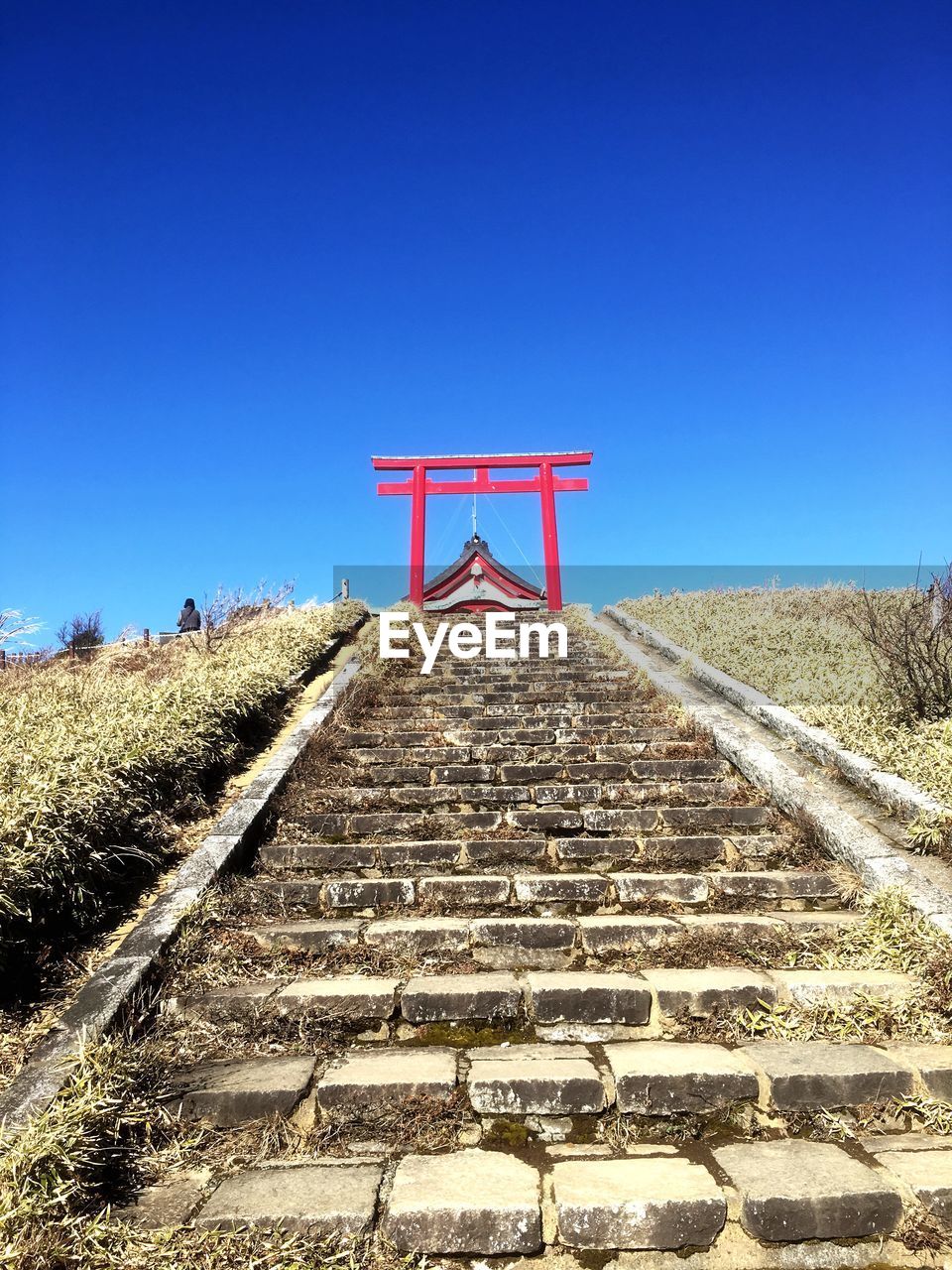 WALKWAY ON FIELD AGAINST CLEAR BLUE SKY