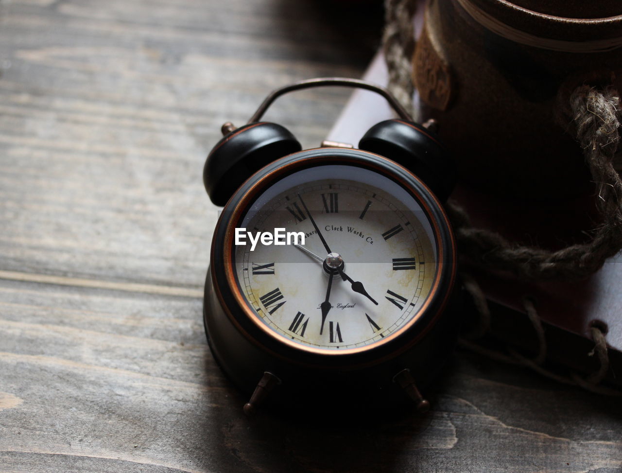 HIGH ANGLE VIEW OF CLOCK ON WOODEN TABLE