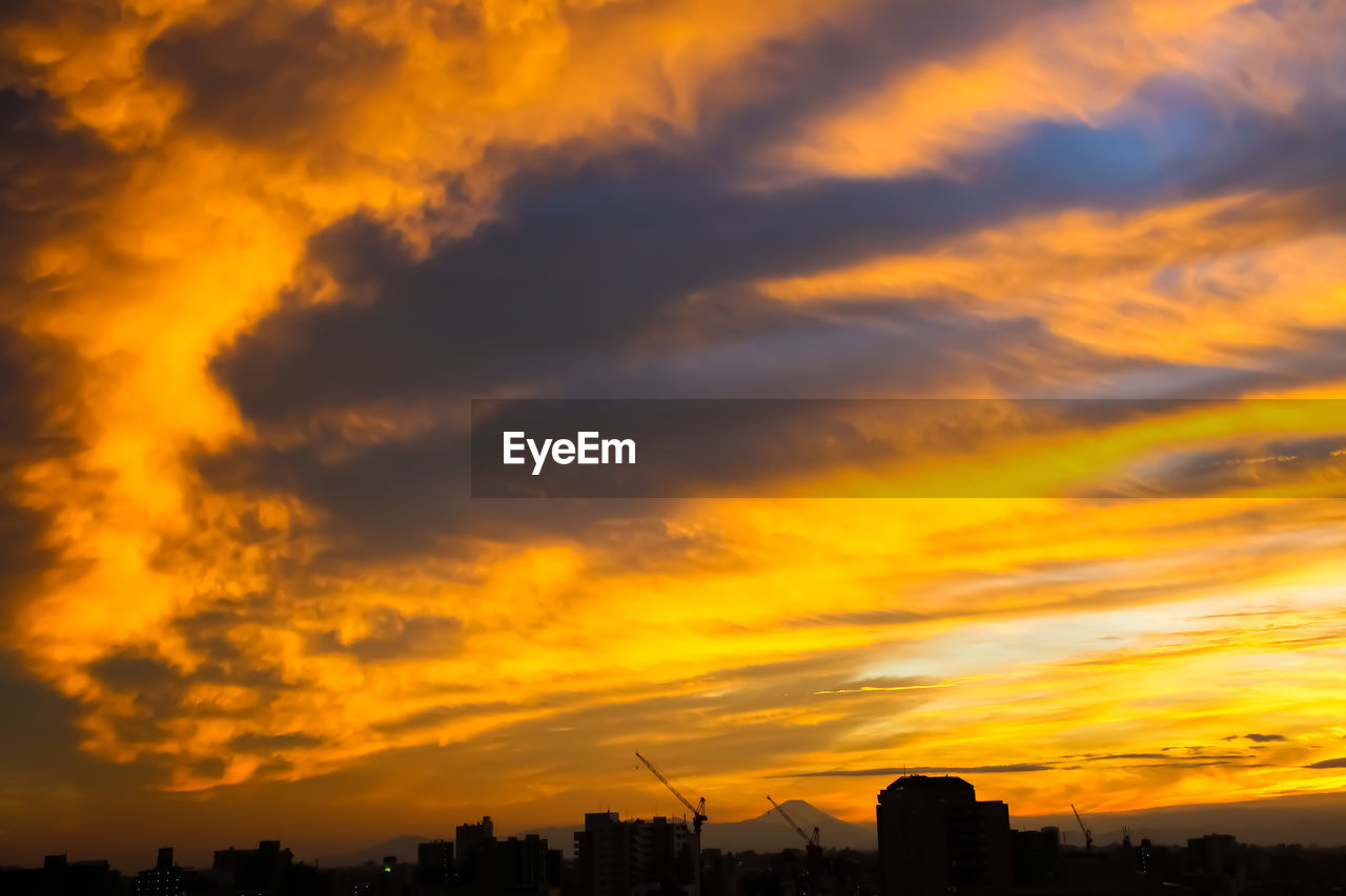 sky, cloud, afterglow, sunset, architecture, dramatic sky, building exterior, city, red sky at morning, orange color, built structure, nature, silhouette, beauty in nature, horizon, landscape, dawn, cityscape, building, urban skyline, scenics - nature, no people, evening, environment, outdoors, cloudscape, yellow, sunlight, sun, moody sky, travel destinations, tranquility, residential district, atmospheric mood, multi colored, storm, city life, dark, vibrant color, idyllic