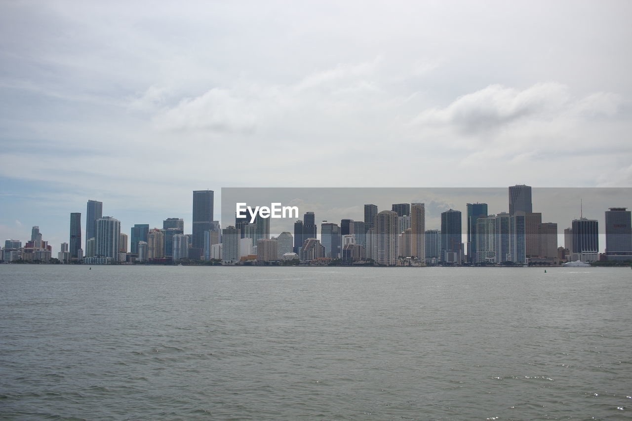 SEA AND BUILDINGS AGAINST SKY IN CITY