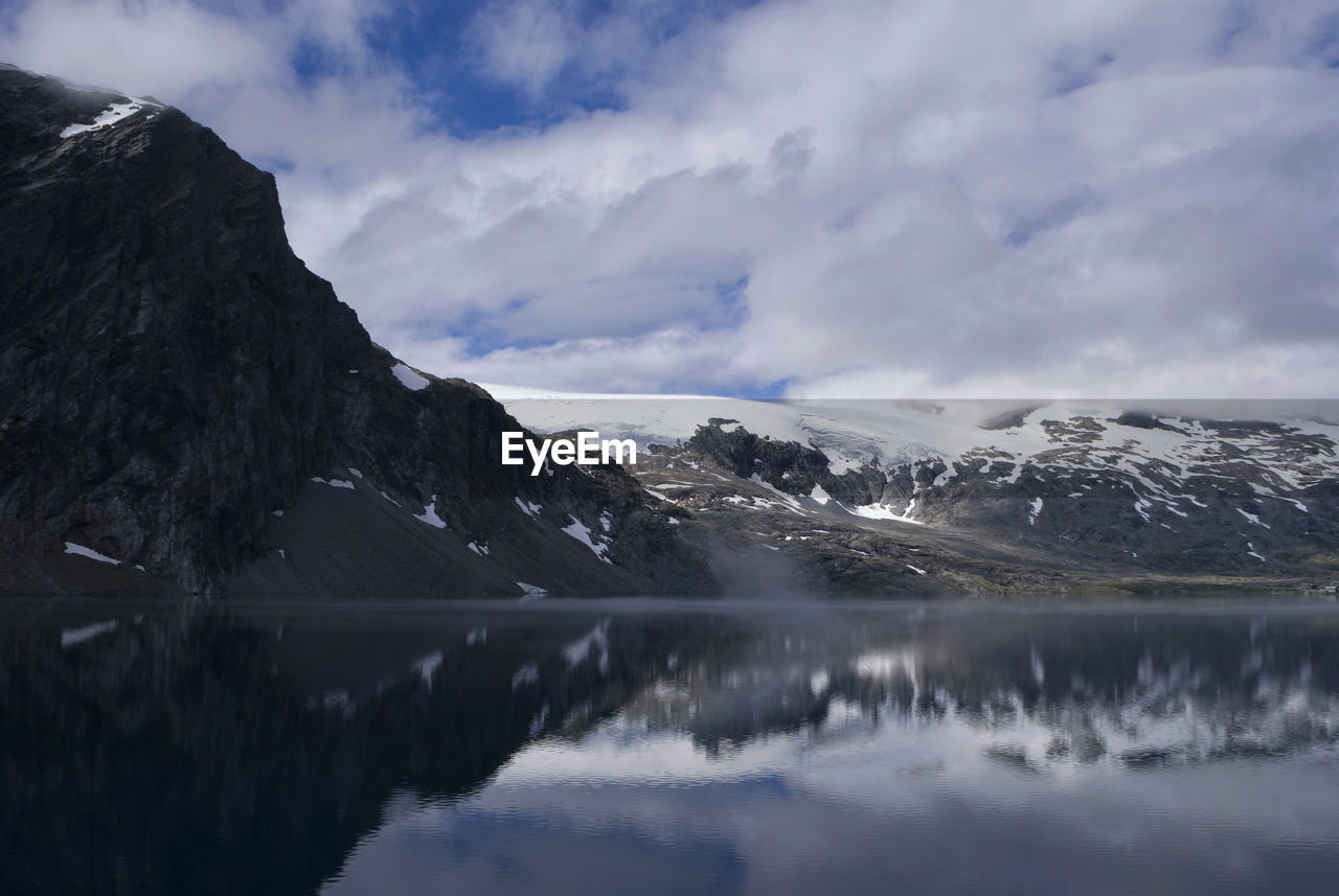 Scenic view of lake and snowcapped mountains against sky