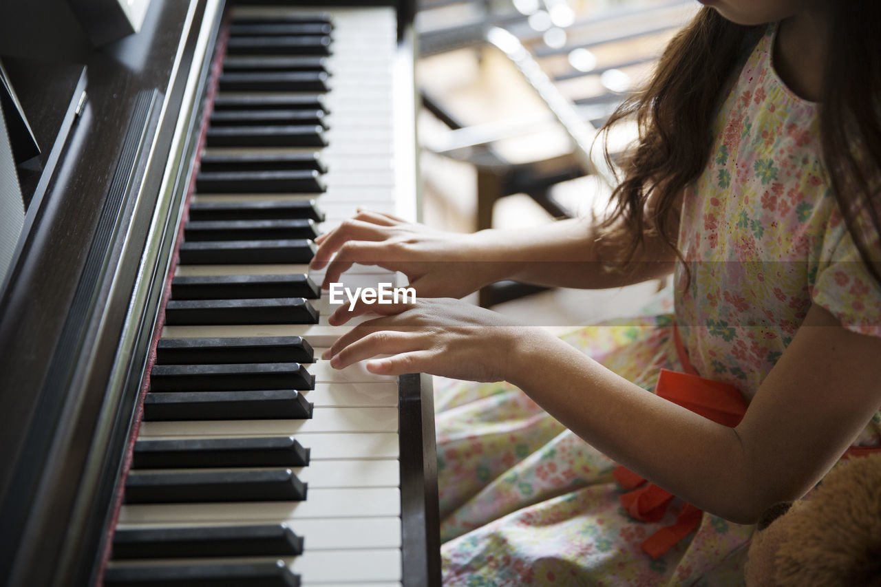 High angle view of girl playing piano at home