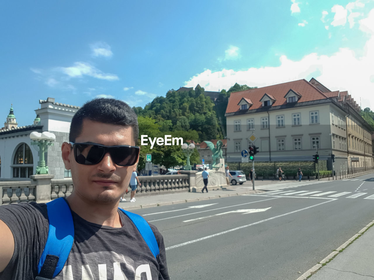 PORTRAIT OF YOUNG MAN WEARING SUNGLASSES STANDING ON ROAD