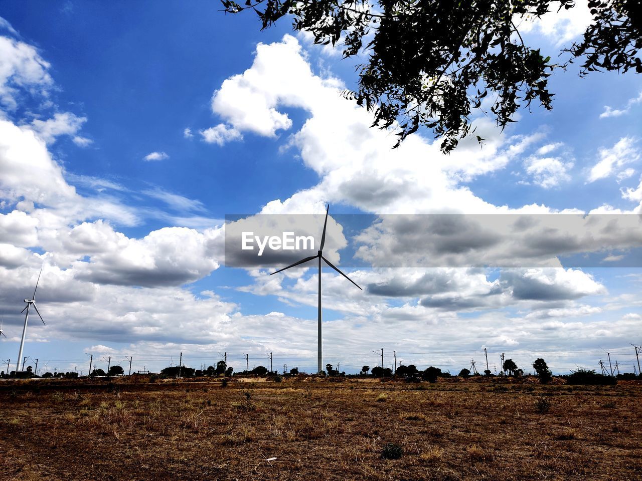 LOW ANGLE VIEW OF WIND TURBINES ON LAND AGAINST SKY