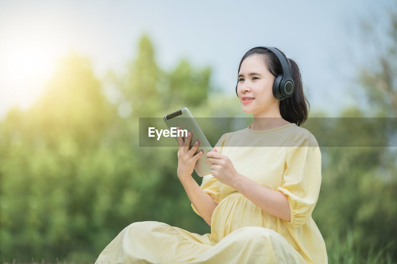 YOUNG WOMAN USING SMART PHONE