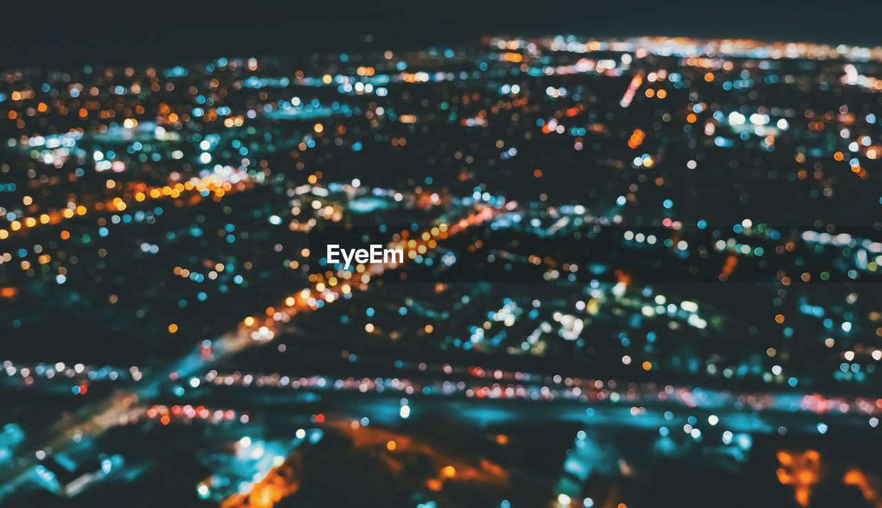 HIGH ANGLE VIEW OF ILLUMINATED CITYSCAPE AT NIGHT