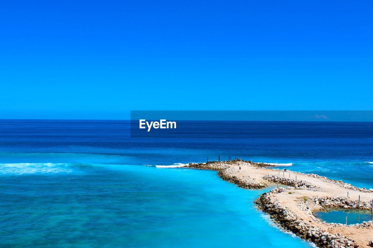 Scenic view of sea against clear blue sky