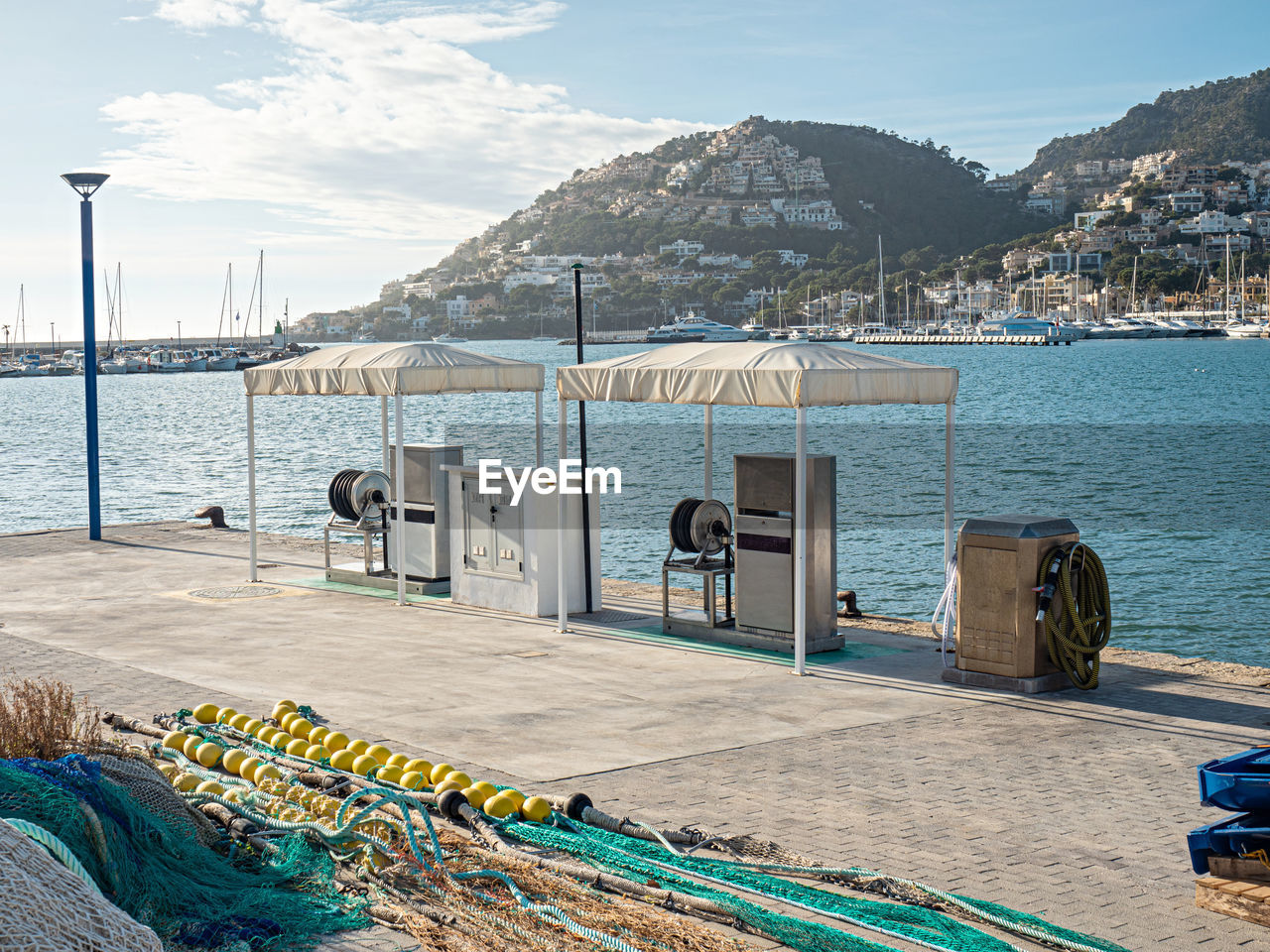 Empty gas station. fishing net in foreground, sea fishing port. port d'andratx, mallorca