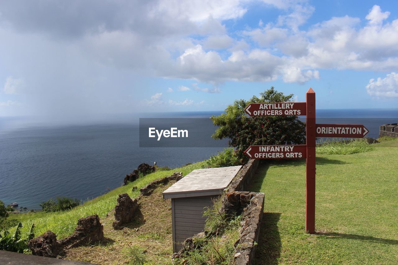 INFORMATION SIGN ON SEA SHORE AGAINST SKY