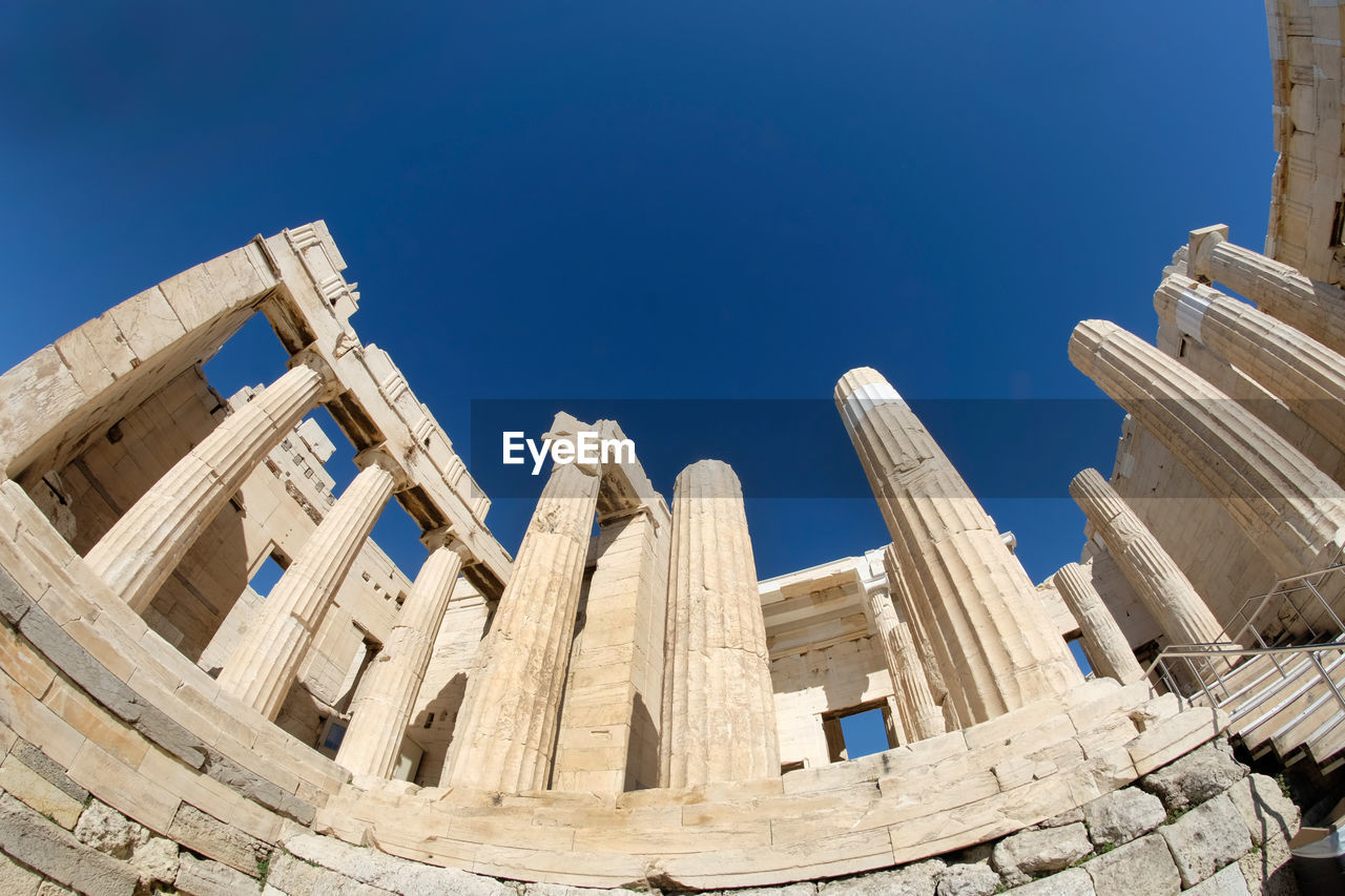 Low angle view of old ruins against clear blue sky