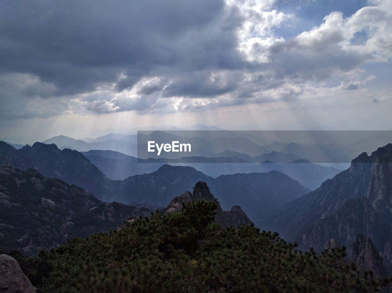 Scenic view of mountain range against cloudy sky