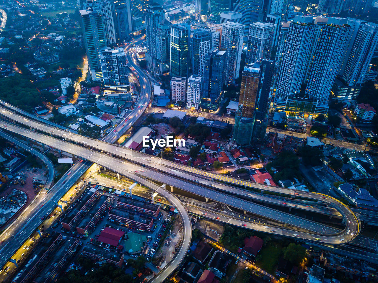 Aerial view of illuminated highway amidst buildings at night