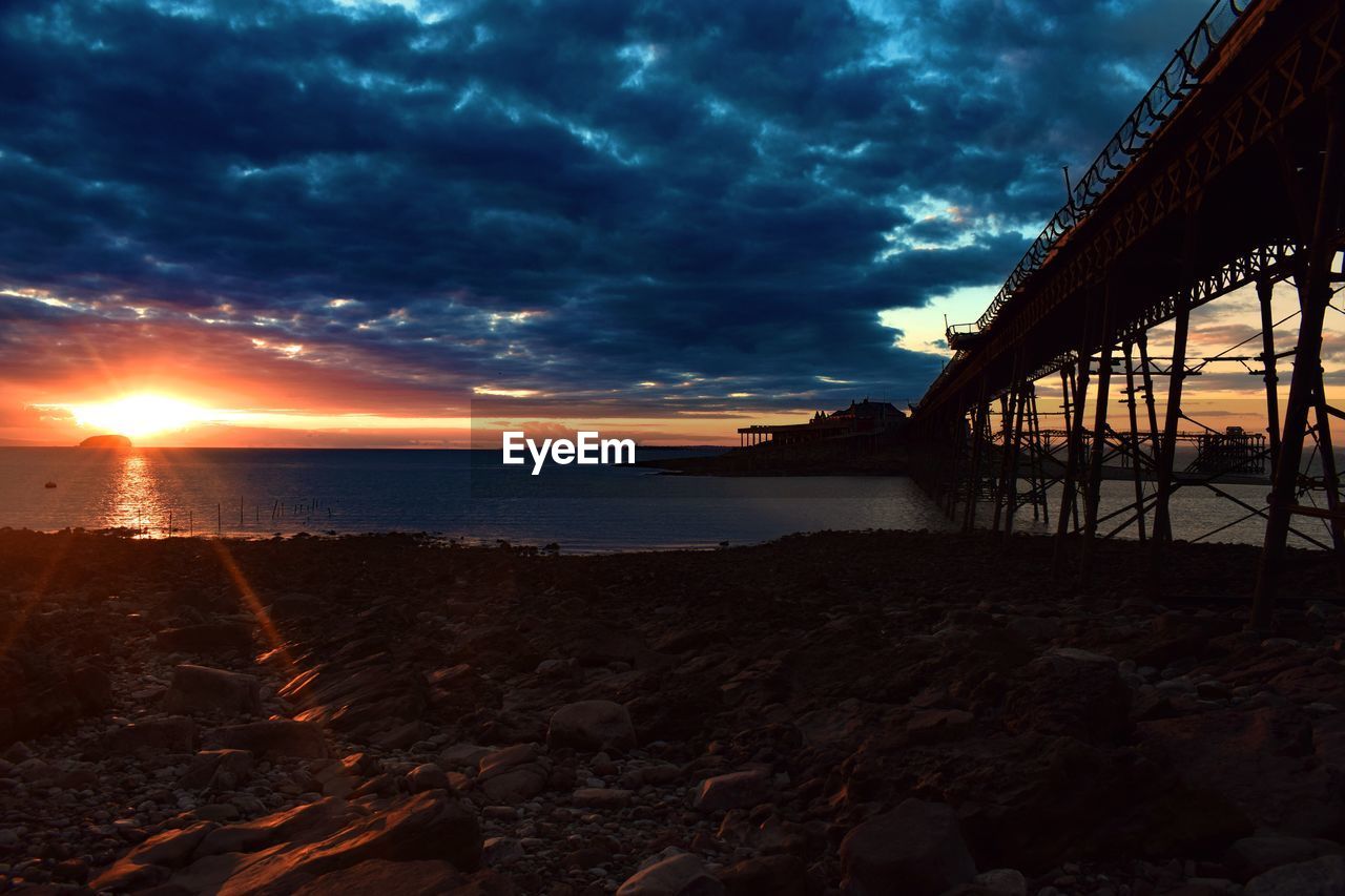 VIEW OF CALM SEA AGAINST DRAMATIC SKY