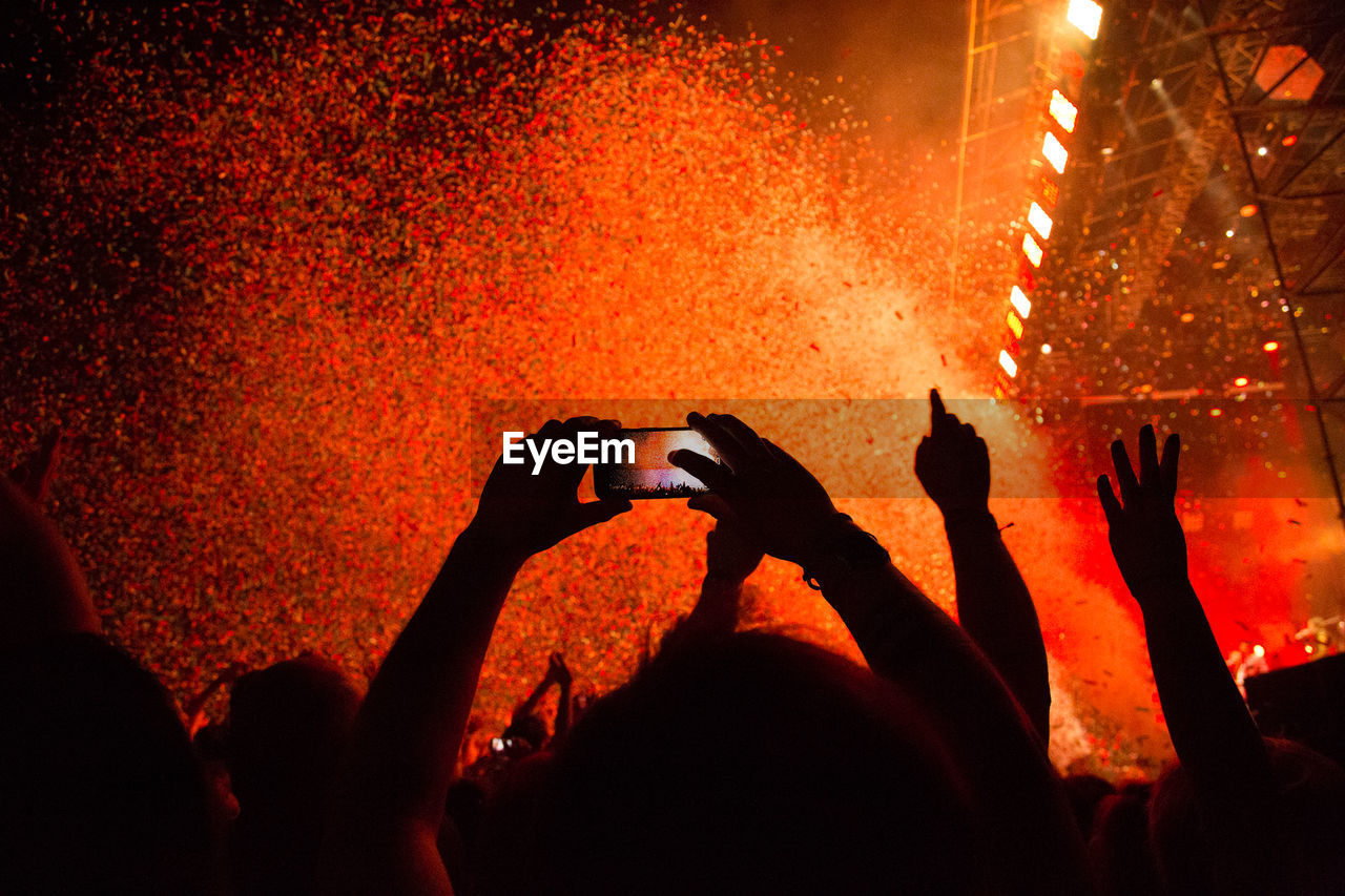 Silhouette of people photographing at concert