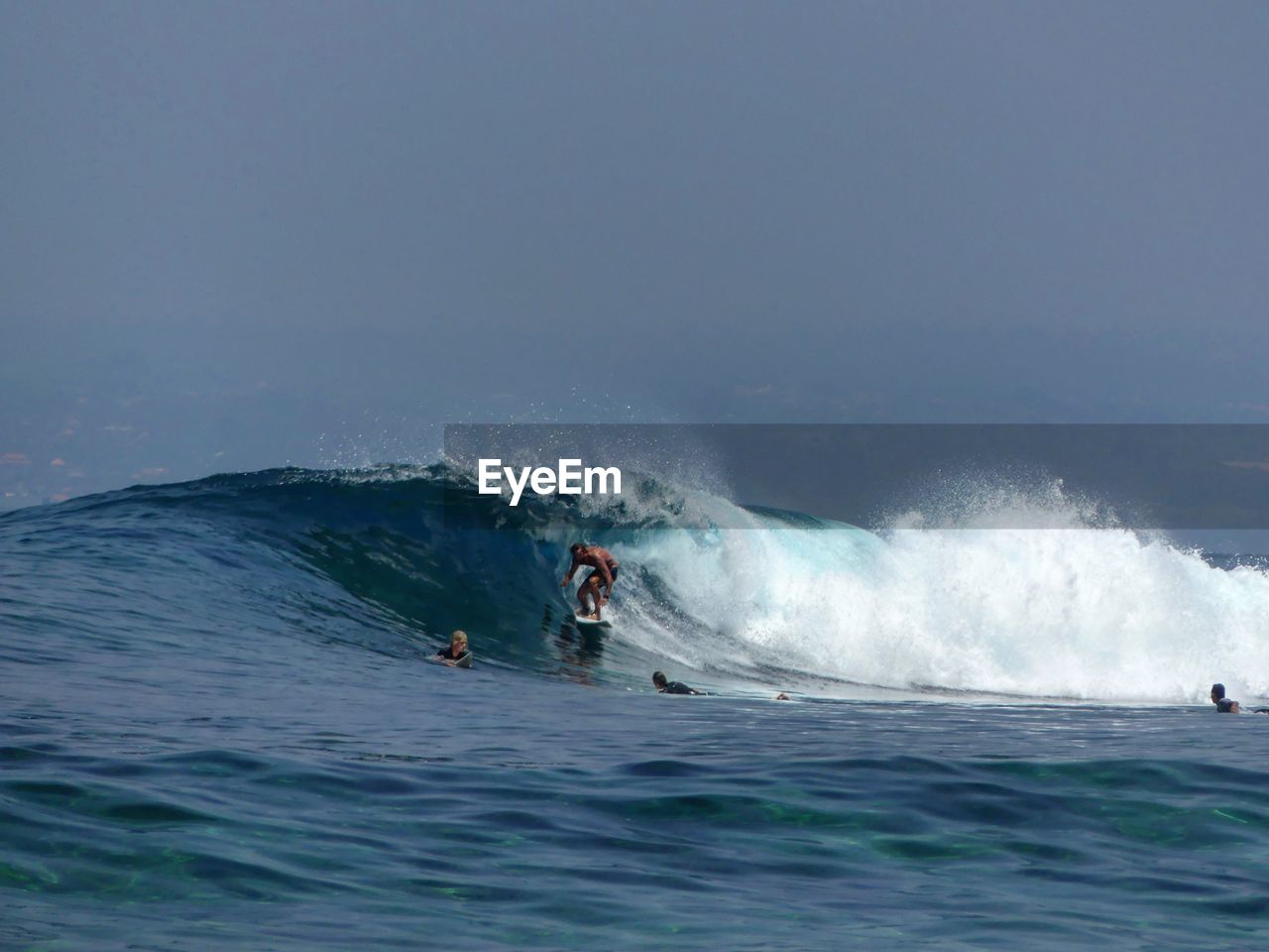 MEN SURFING ON SEA AGAINST SKY