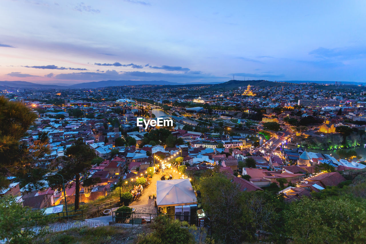 Sunset panorama view of tbilisi, capital of georgia country. metekhi church, holy trinity cathedral.