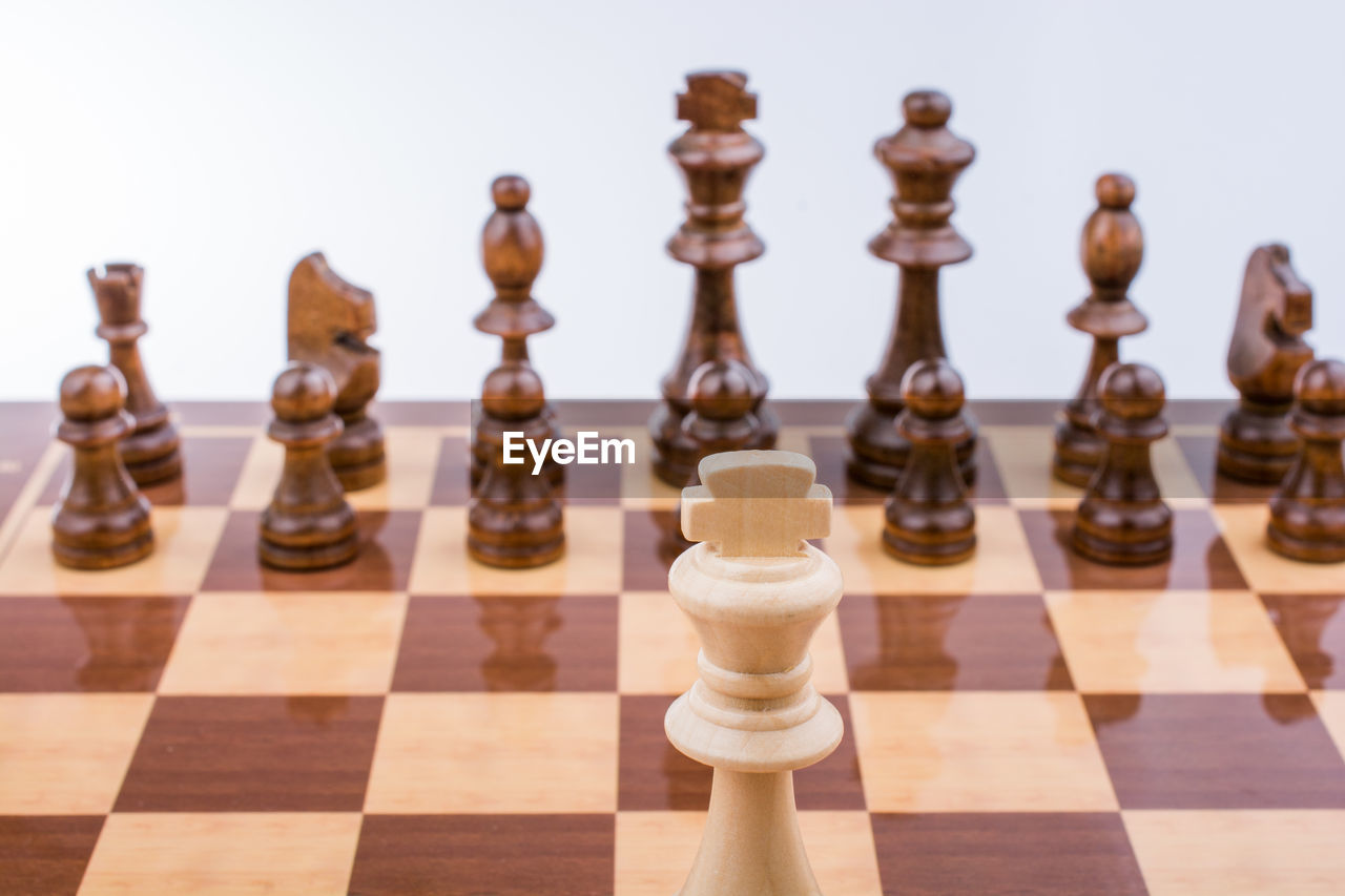 High angle view of chess pieces on board against gray background