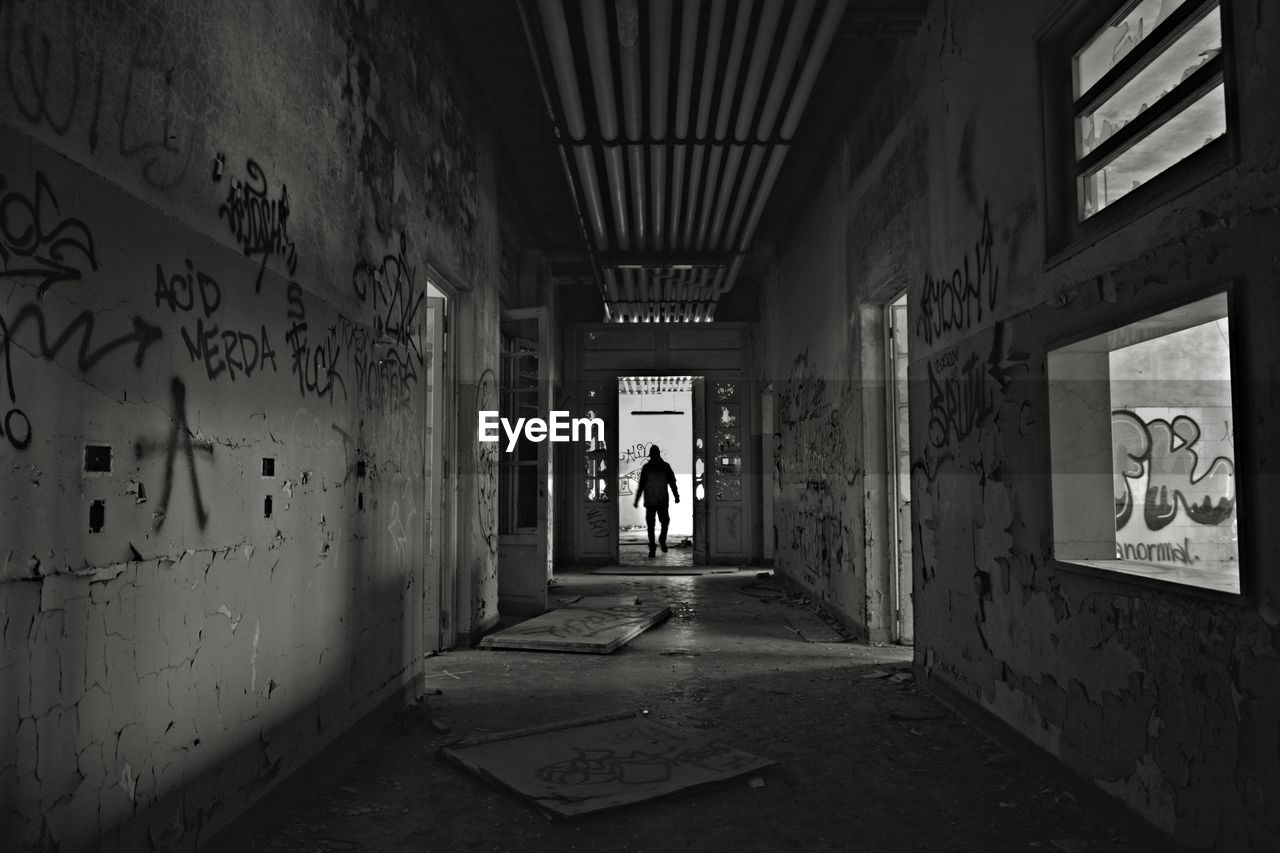 Rear view of man walking in corridor of building