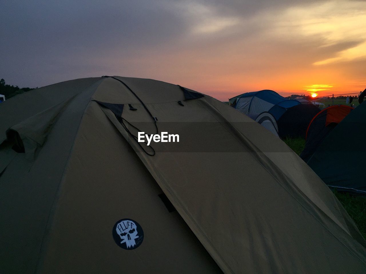 Tents against sky at sunset