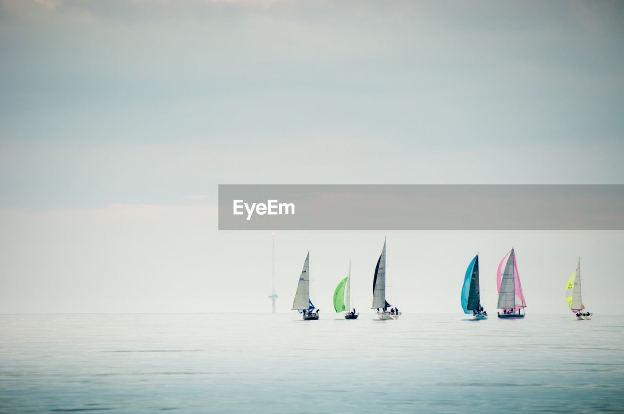 Boats sailing on sea against sky