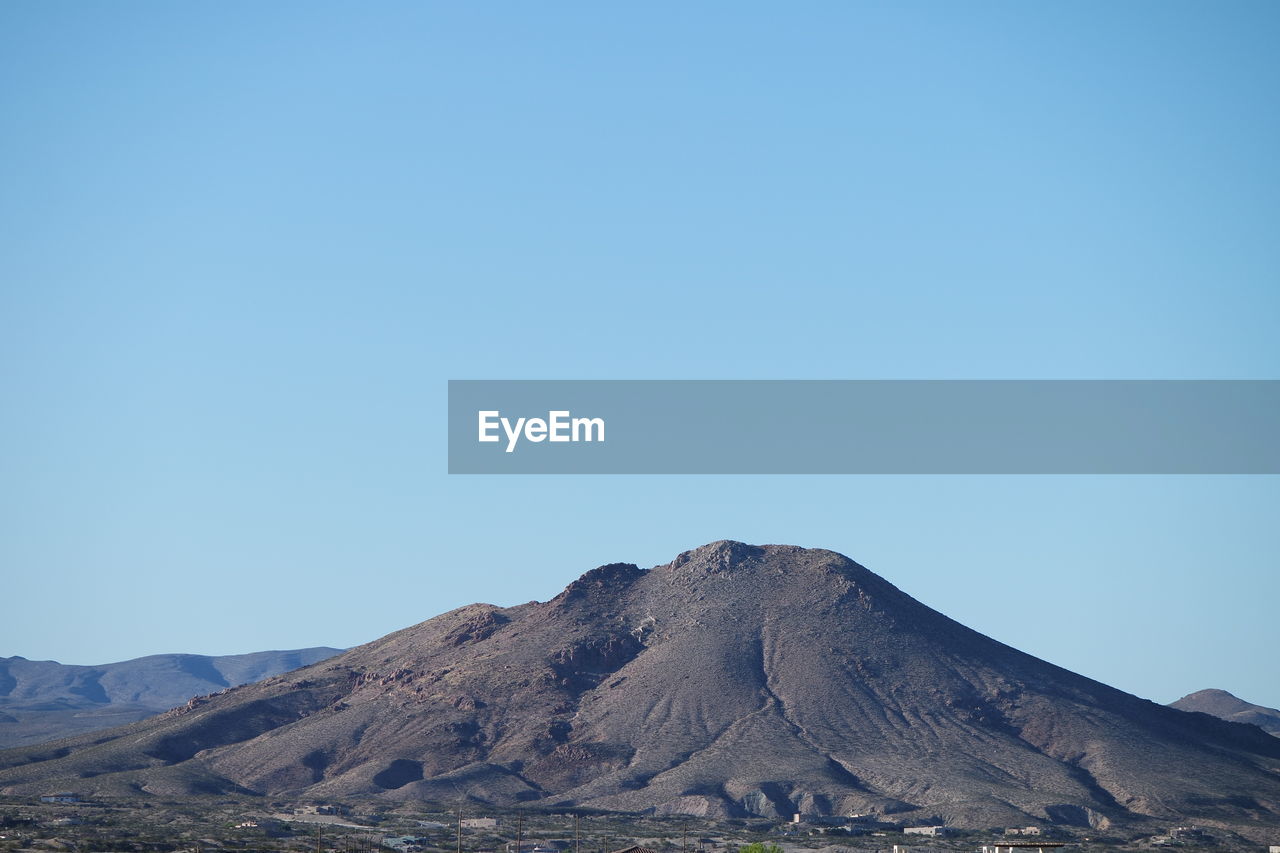 Scenic view of mountains against clear blue sky