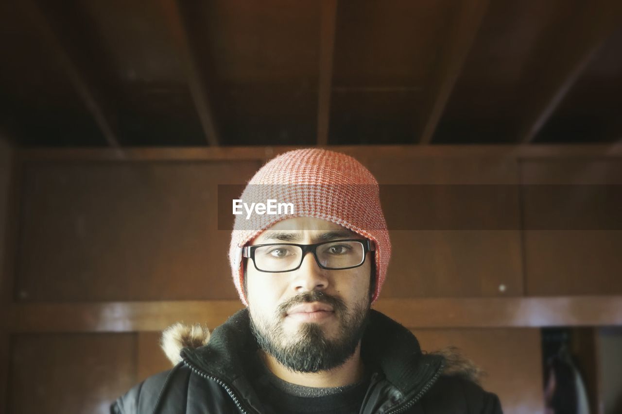 Portrait of bearded man in knit hat at home