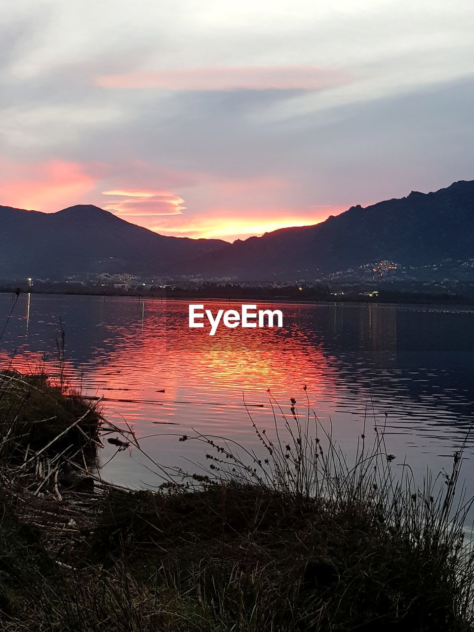 SCENIC VIEW OF LAKE AGAINST SKY AT SUNSET