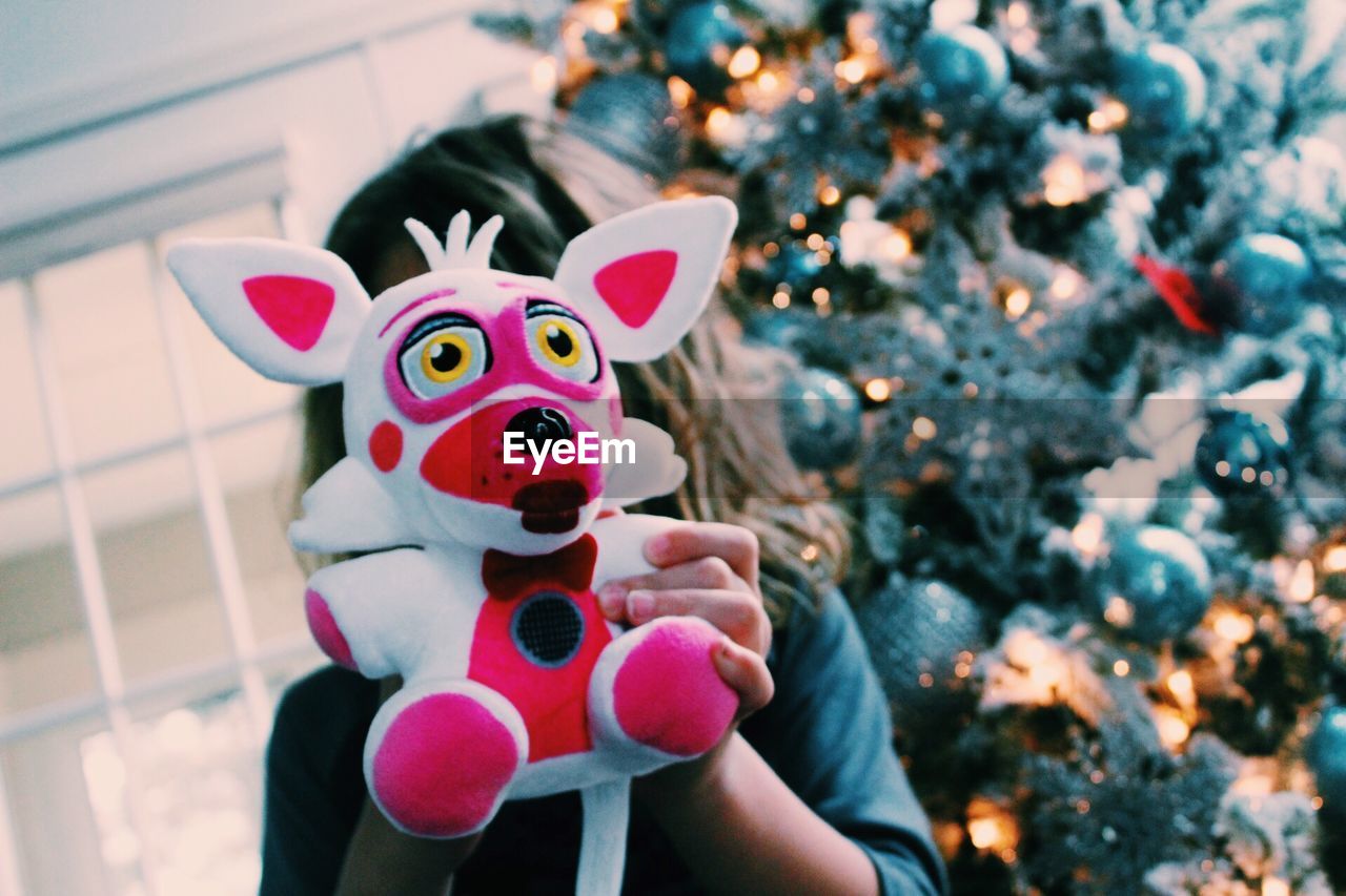 Close-up of girl holding christmas present against face