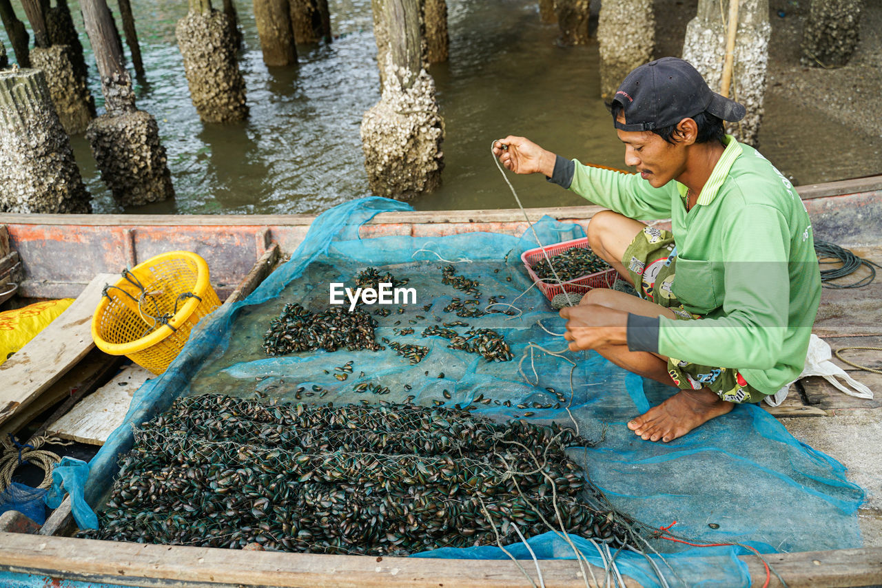 SIDE VIEW OF A MAN WORKING AT WATER