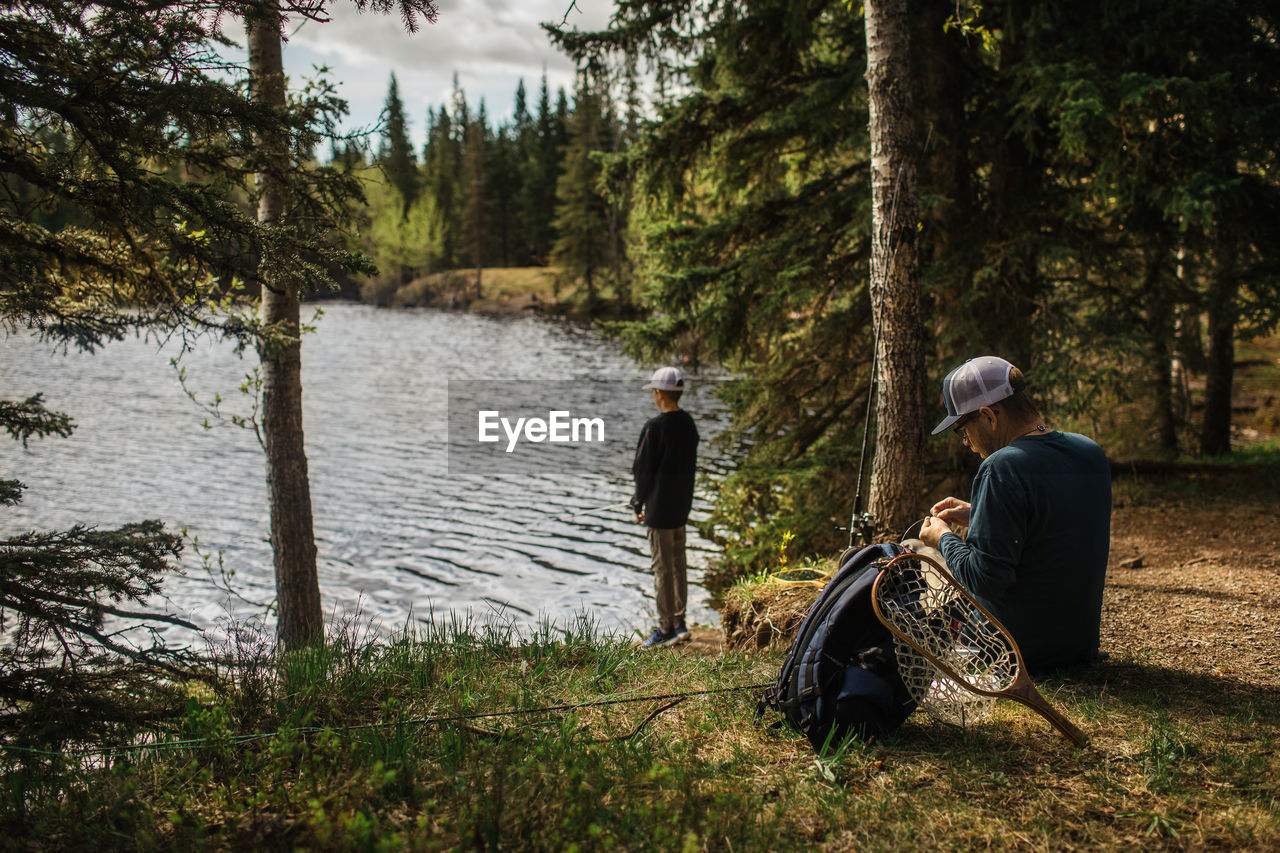 Father preparing fishing line on father/son fishing trip