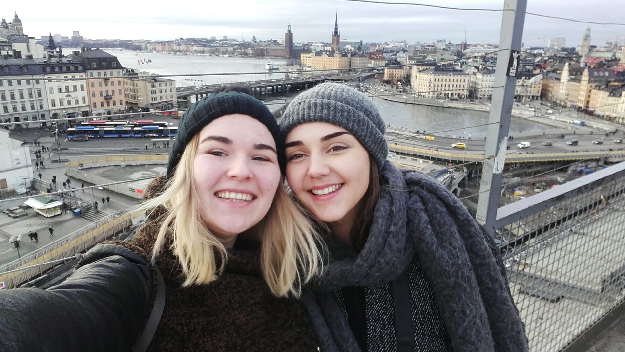 Portrait of happy female friends against cityscape