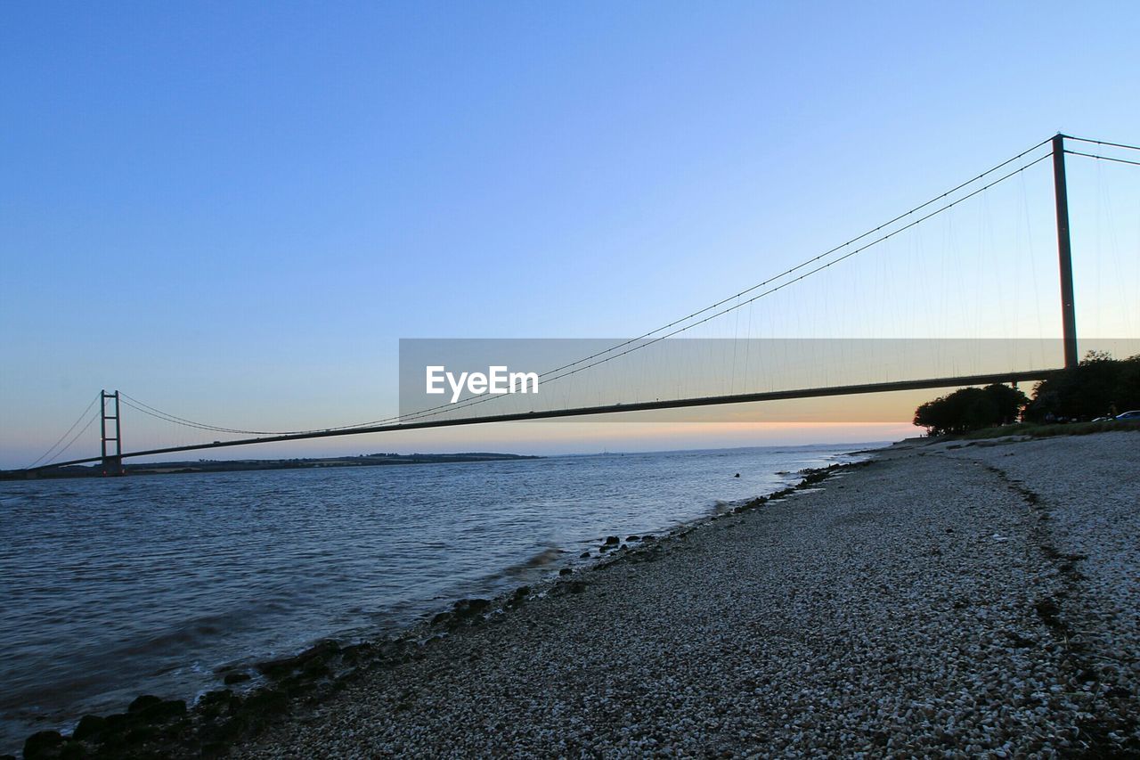 Humber bridge over river against clear sky during sunset