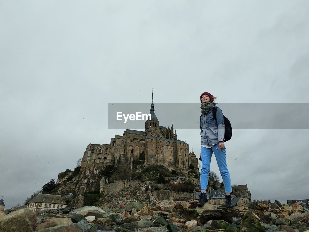 Girl standing on rocks against the mont saint michel