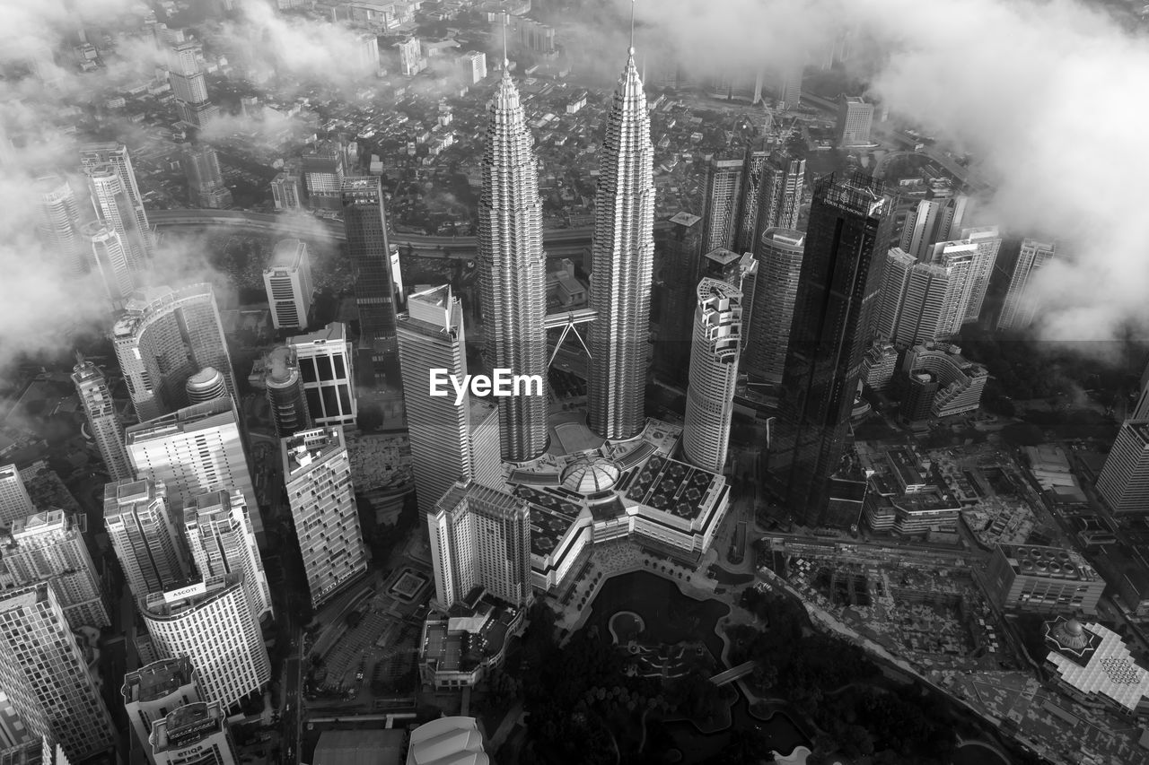 HIGH ANGLE VIEW OF BUILDINGS AGAINST CLOUDY SKY